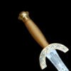 Decorative dagger with gold handle and silver blade on a black background